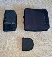 Three black CD cases laid out on carpet