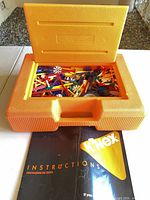 Closed orange carrying case with instruction booklet