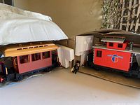 Passenger coach, caboose, conductor figure, cardboard and foam packaging visible