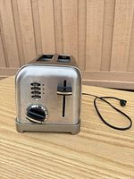 Front view showing control buttons, lever, shade dial, stainless body, power cord