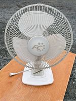 Front view of FC oscillating table fan showing blades, grills, logo, base and cord