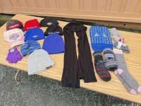 Full lot on table showing hats, gloves, socks, scarf