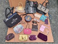 Group shot of all handbags, pouches and wallets laid on cardboard