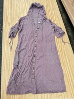 Full view of mauve hooded cardigan dress laid flat showing overall style, length and front button closure.