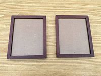 Front view of both wooden frames showing brown cherry finish and glass openings