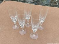 All five crystal champagne flutes standing on surface