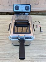 Deep fryer assembled with lid closed, power cord visible