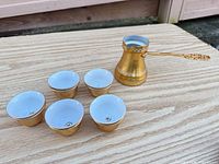 Entire set: five cups and cezve on tabletop