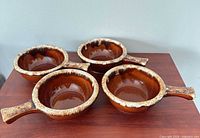Four brown drip Hull soup bowls on table