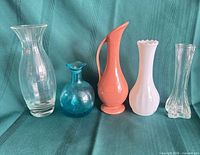 All five vases standing side by side on green fabric backdrop