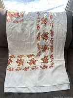 Tablecloth draped on sofa showing floral border and fabric texture