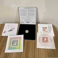 Overview of silver coin in presentation case with four keepsake cards