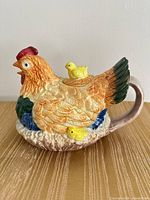 Side view of hen-shaped ceramic teapot with chicks