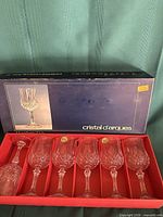 Open box showing six crystal wine glasses seated in red insert and box lid