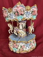 Front view of carousel music box showing overall design and three horses