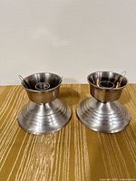 Pair of silver-tone brass candle holders front view