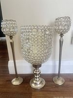 Front view of all three crystal hurricane candle holders on floor