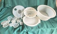 All Tupperware pieces laid out including cake carrier components, jel-ring body, lid and inserts