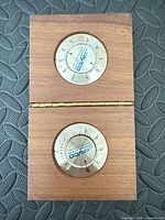 Wood folding case opened showing two Avco dials