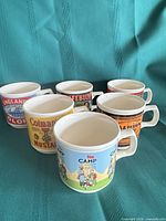 Group of six advertising mugs showing multiple label designs