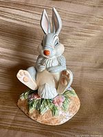 Front view of ceramic Thumper figurine seated on floral base