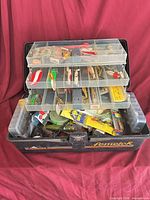 Open Fenwick tackle box showing multiple trays full of assorted lures and tackle
