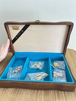 Open jewelry box showing brooches in compartments