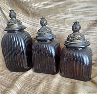 Front view of all three amber ribbed glass canisters with lids attached