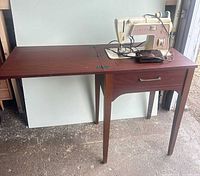 Singer sewing machine on wooden folding table, full view