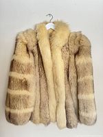 Front view of fox fur coat on hanger showing colour and shape