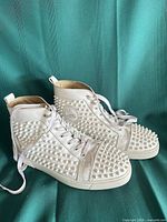 Both sneakers side view showing spikes and overall condition