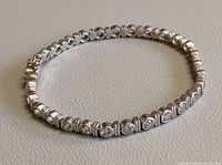 Full view of silver bracelet in circular form showing crystal settings
