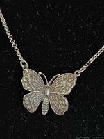 Close-up of sterling butterfly pendant on chain