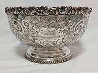 Full view of ornate silver-plated punch bowl on pedestal base