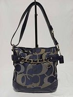 Front view of Coach Op Art duffle bag showing chain detail and hangtag