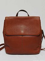 Front view of Fossil Claire brandy leather backpack showing flap and overall shape