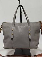 Front view of gray Fossil Jenna satchel showing handles, leather texture, brass studs