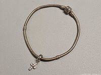 Bracelet laid flat with cross charm visible