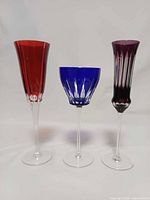 Group shot of three colored cut-to-clear crystal stemware pieces