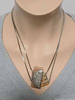 Pendant necklace displayed on mannequin, front view