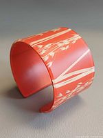 Oblique view of coral resin cuff showing plant inclusions