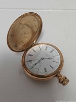 Front view with open cover showing dial and hands