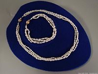 Necklace and bracelet laid out on blue display pad