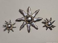 Front view of brooch and earrings showing sunburst design and finish