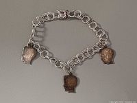 Full view of bracelet showing links and three charms
