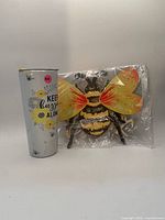 Front view showing tumbler graphic and packaged painted bee décor