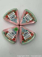 Four packaged triangular bath bombs arranged in a circle