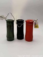 Front view of three LightWay mini LED flashlights / lanterns in green camo, black and red