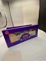 Front of both sealed Mondo Llama kits showing window with wood shapes and paint pots