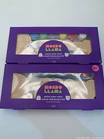 Front view showing two sealed Mondo Llama kits in window boxes